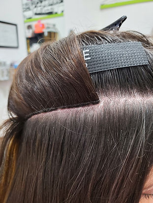 A row of brown hair Invisible Bead Extensions in Williston Vermont. Ego Salon Vermont.