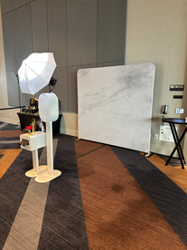 Indoor Photo Booth in front of a white marbled backdrop with props in the background.