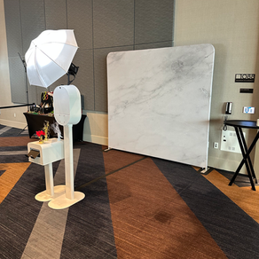 Guac photo booth in front of white marble tension fabric backdrop.