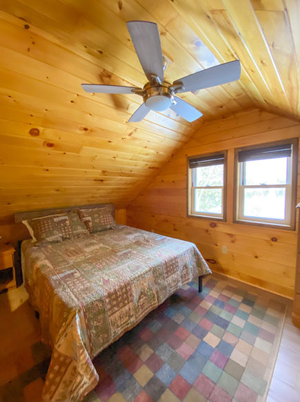 upstairs bedroom with queen bed and dresser