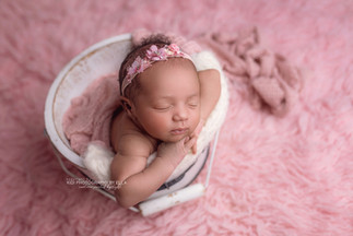 Professional newborn portrait of a baby wrapped in soft cream fabrics
