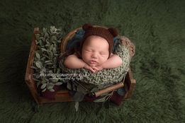 Newborn baby photographed from above in a soft styled set-up at a professional newborn photography studio in Wolverhampton.