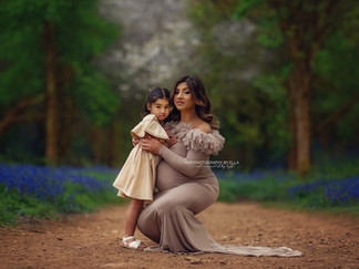 Mother cuddling her child in a dreamy bluebell forest mini session