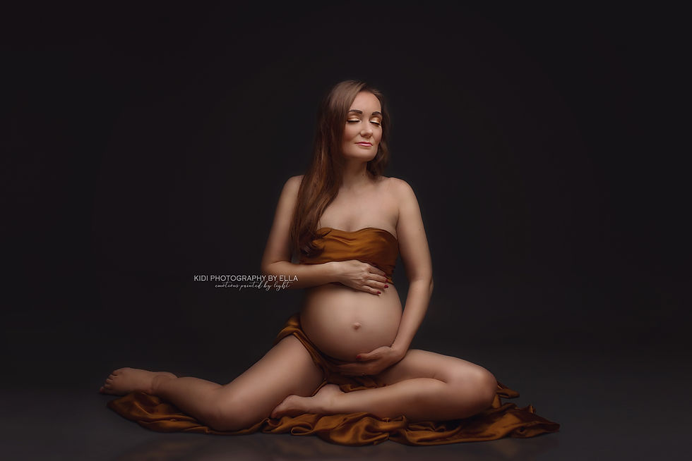 Maternity studio session with graceful pose and soft fabric movement