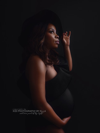 Studio maternity glamour session with flowing dress and feminine pose