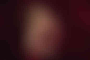 Mum sitting with baby on lap smiling in cosy lifestyle-style photoshoot