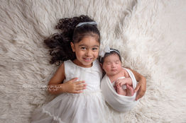 Tiny newborn baby wrapped in soft beige layers