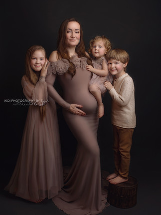 Artistic pregnancy photoshoot in studio with soft shadows and elegant mood