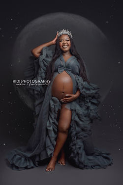 xpecting mother in flowing gown studio portrait
