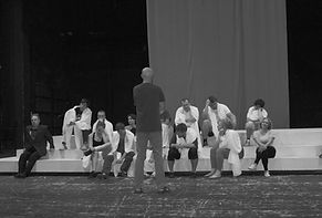 Theatre directing programme for beginners rehearsal with director guiding actors on stage during scene work and ensemble training.