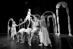 Group of performers creating ensemble stage movement and physical composition on stage