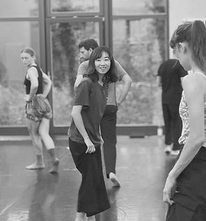 Performers interacting during a physical theatre workshop, exploring partner work and improvisation in a studio setting at NIPAI