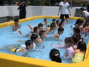 子供たちがプールで遊んでいる様子。水遊び、夏の思い出、楽しそうな笑顔が印象的です。