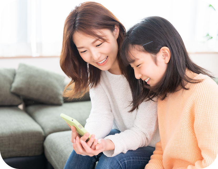 笑顔でスマホを見る親子