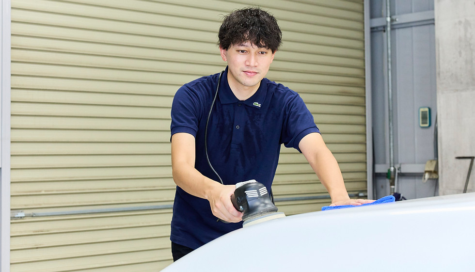 雹害車を修理している男性