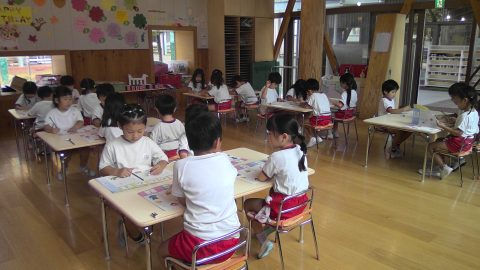 園児たちが机に向かい何かを描いています。6月【年少々】今週の様子。教室で集中している様子。