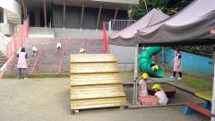 園庭で遊ぶ子供たち、木製の階段と滑り台。12月【年少】 クリスマス会、保育園の風景。