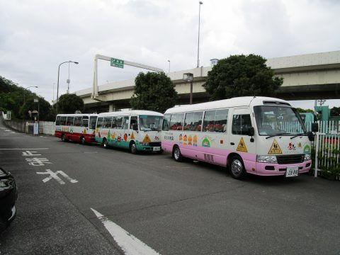 幼稚園バスが3台並んでいる、道路際に停車中。看板あり。 全学年　自然観察公園にて・・・