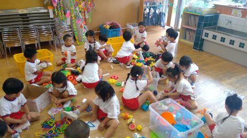 園児たちが床に座って遊んでいる様子。おもちゃで遊ぶ姿、4月【年長】今週の様子です。