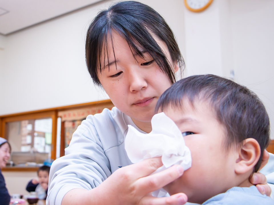 子供の鼻を拭く女性