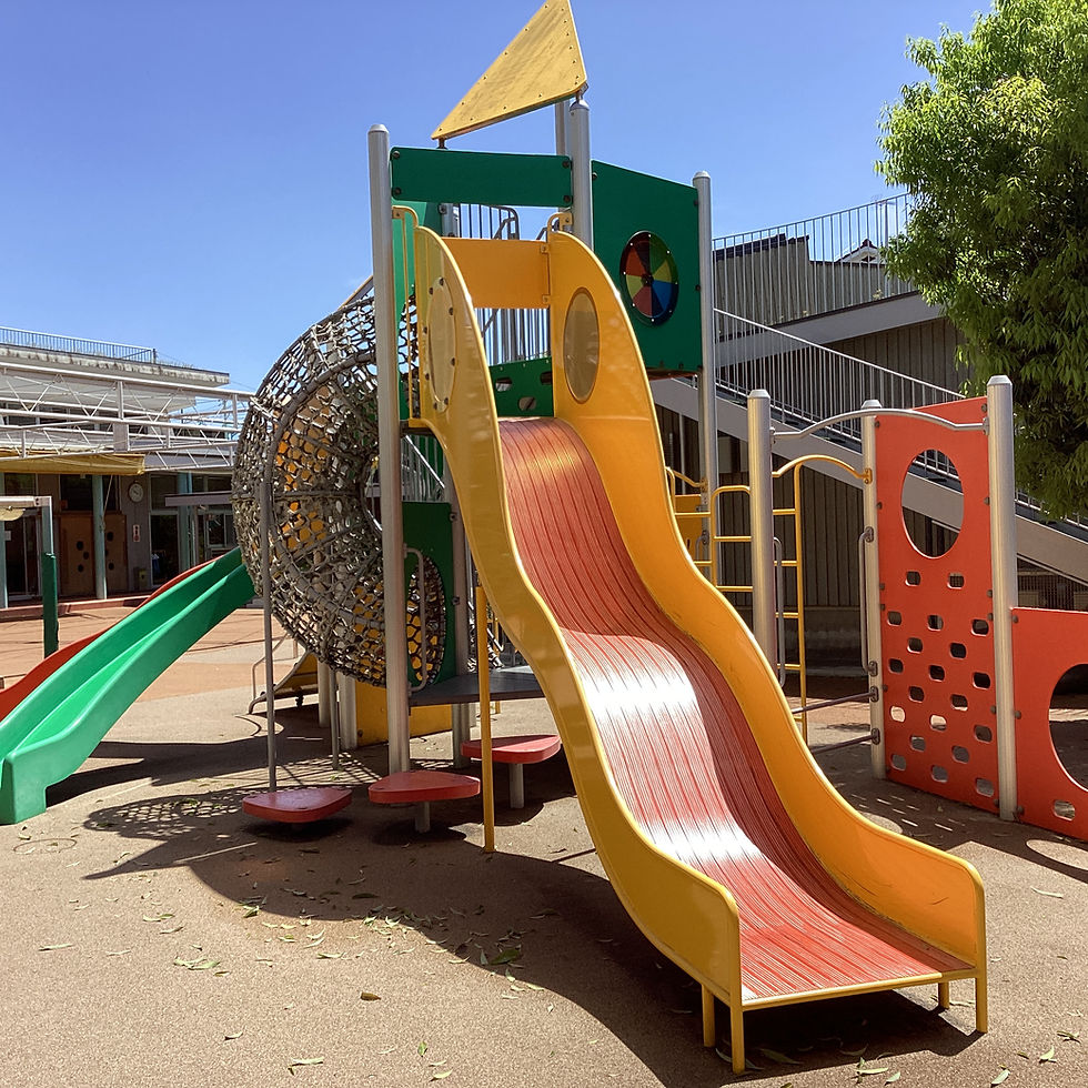 明るい色の滑り台と遊具。砂場、青空の下、子供たちが遊ぶ場所。