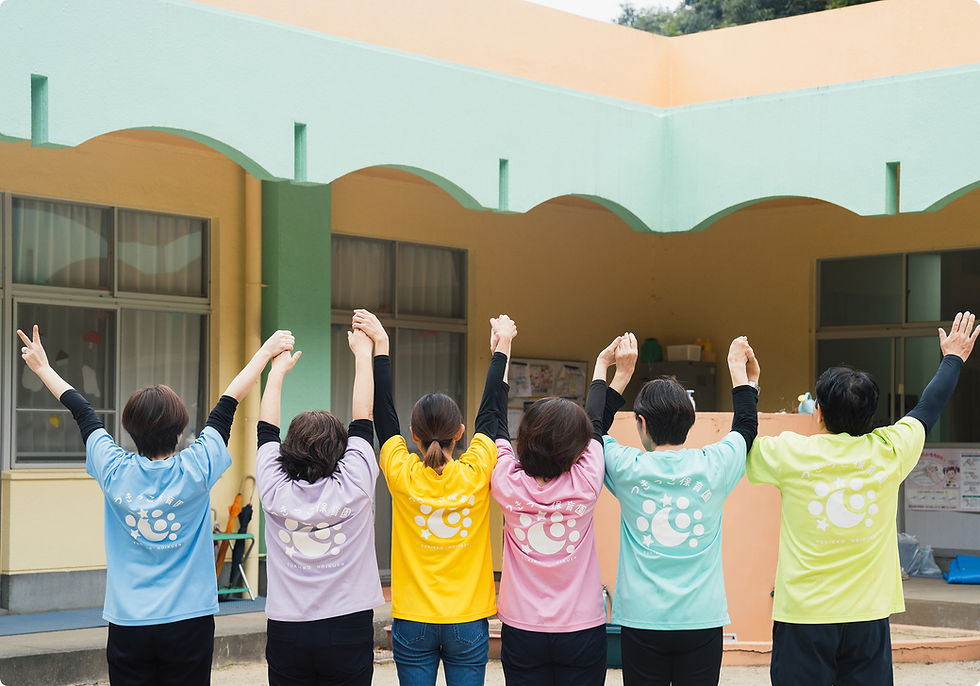 カラフルなTシャツを着て手を上げる6人のスタッフ