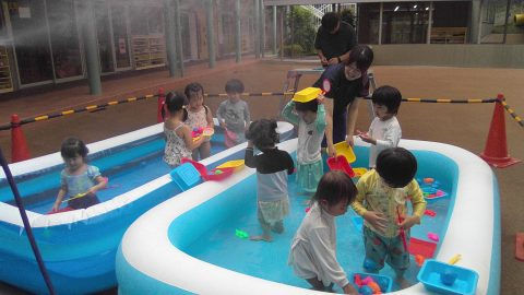 幼児がプールで遊んでいる様子。先生と6月【年少々】今週の様子を見守る。夏です。