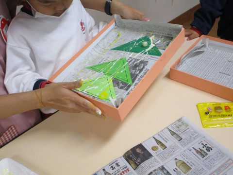 子供が箱でスタンプ遊びしています。6月【年少々】スタンプ遊び、芸術的な風景が展開されます。