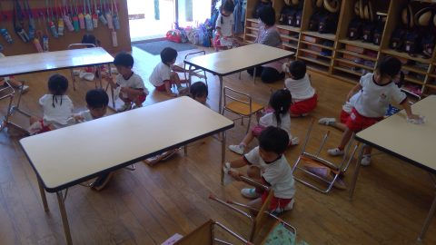 保育園の子供達が教室で遊んでいる様子、白いシャツと赤いズボン。2月【年少々】今月の様子