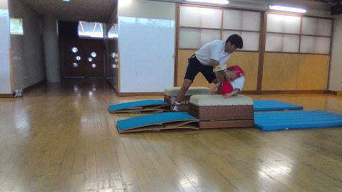 保育士が子供をサポートしています。子供が台の上を移動しています。１２月【年中】今週の様子