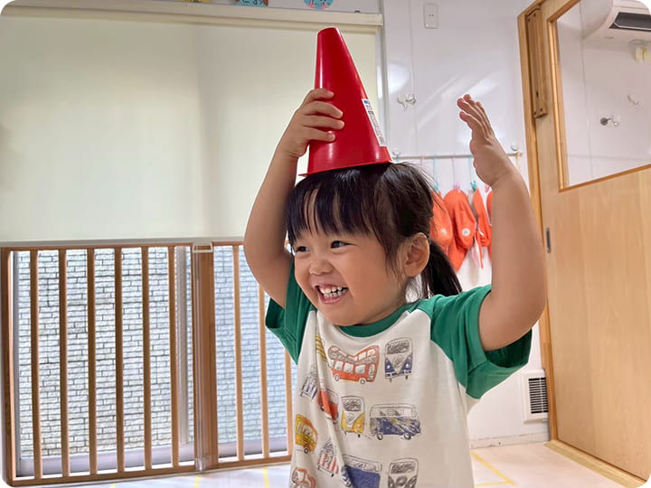 赤い帽子をかぶって笑顔の女の子、マジオブルームキッズ、楽しそうに笑う。