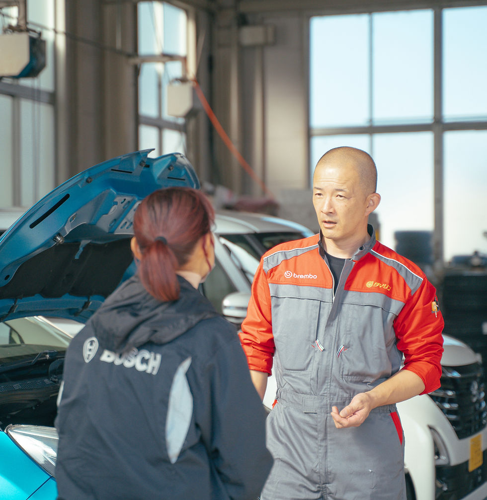 整備士が顧客と話す様子 Bosch ロゴ 車 トップ 整備工場