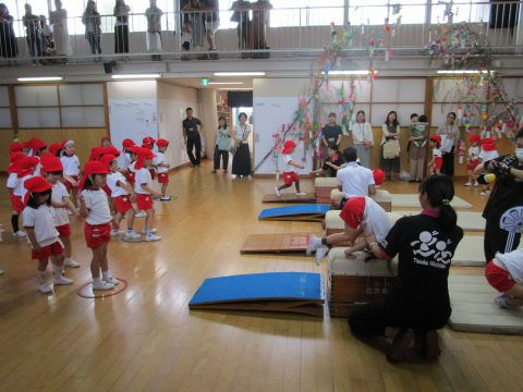 子供たちが体操を披露、観客席には保護者。年長組　参観日、運動会に向けて練習している様子。