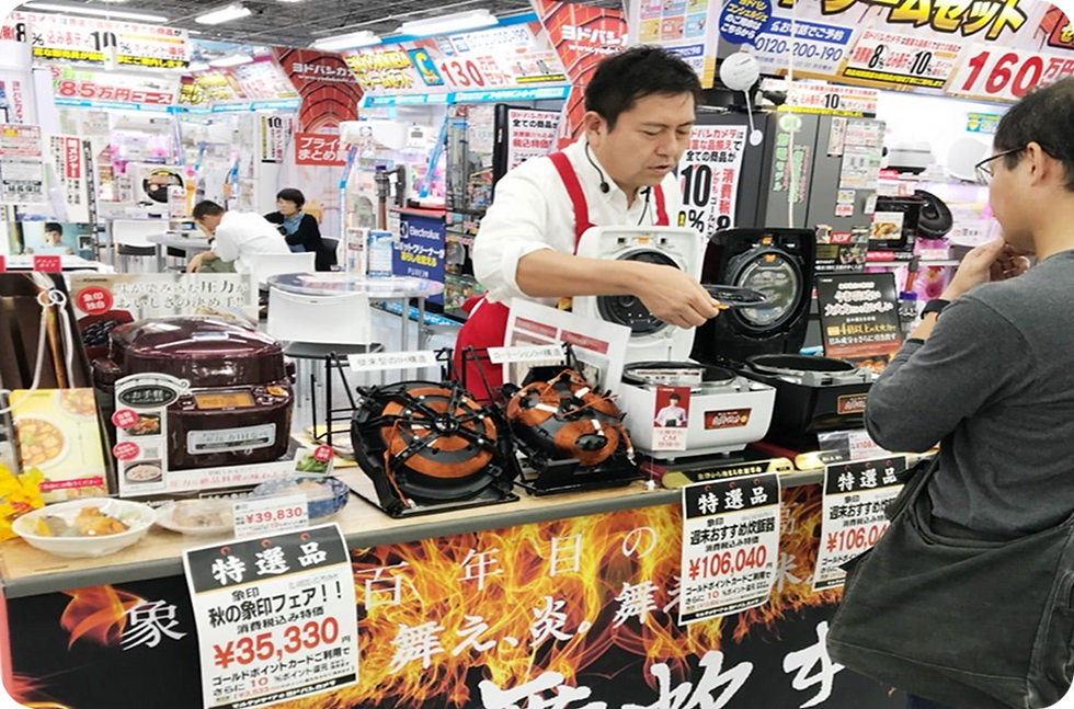 特選品の炊飯器を客に実演販売する店員。