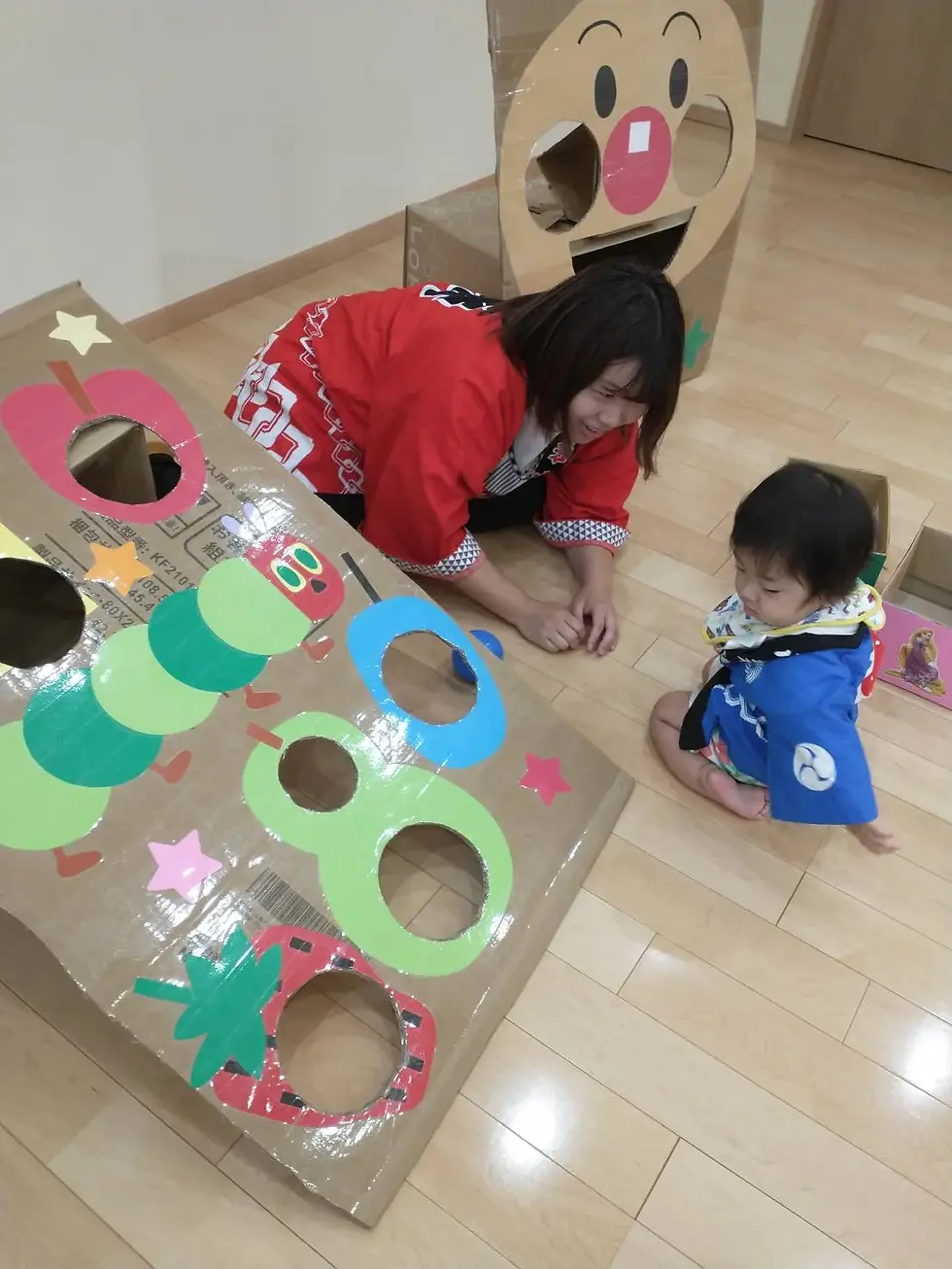 段ボール工作で遊ぶ子供と大人