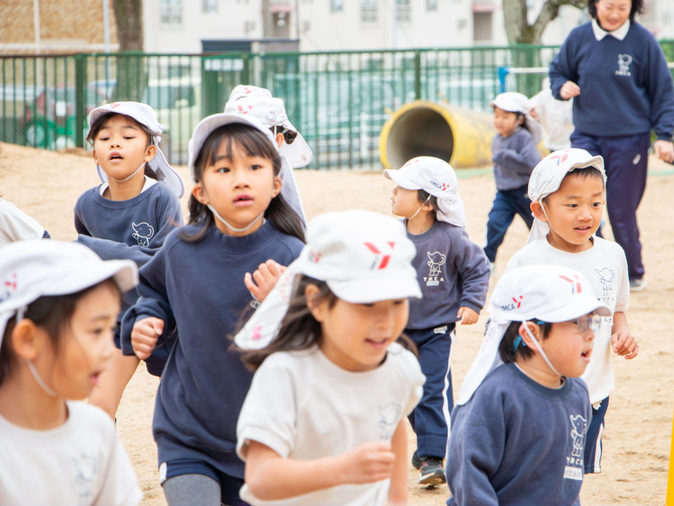 園庭で走る幼稚園児たち