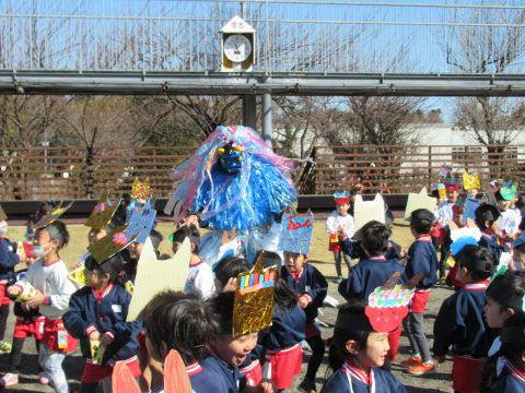 青い鬼と園児たち、手作りの帽子をかぶり楽しそうに遊んでいます。年少組　散歩。