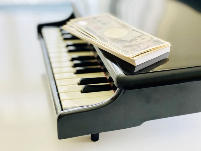 ピアノのオモチャの上にのせた1万円札