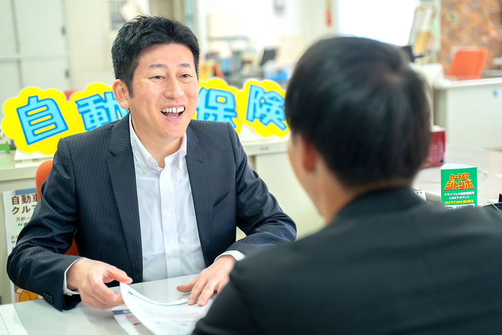 自動車保険の相談で笑顔で接客する男性スタッフ