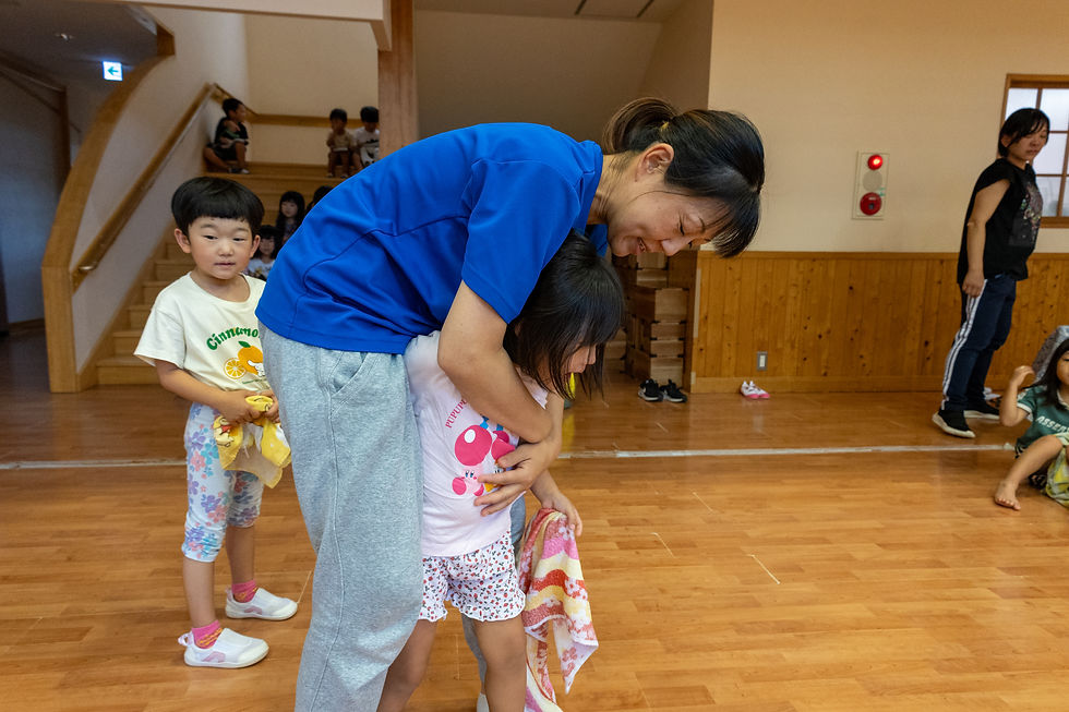 園児を抱きかかえてサポートする保育士の様子