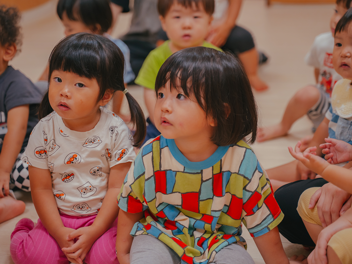 子供達が座って見ている様子。周りにいる子供達。