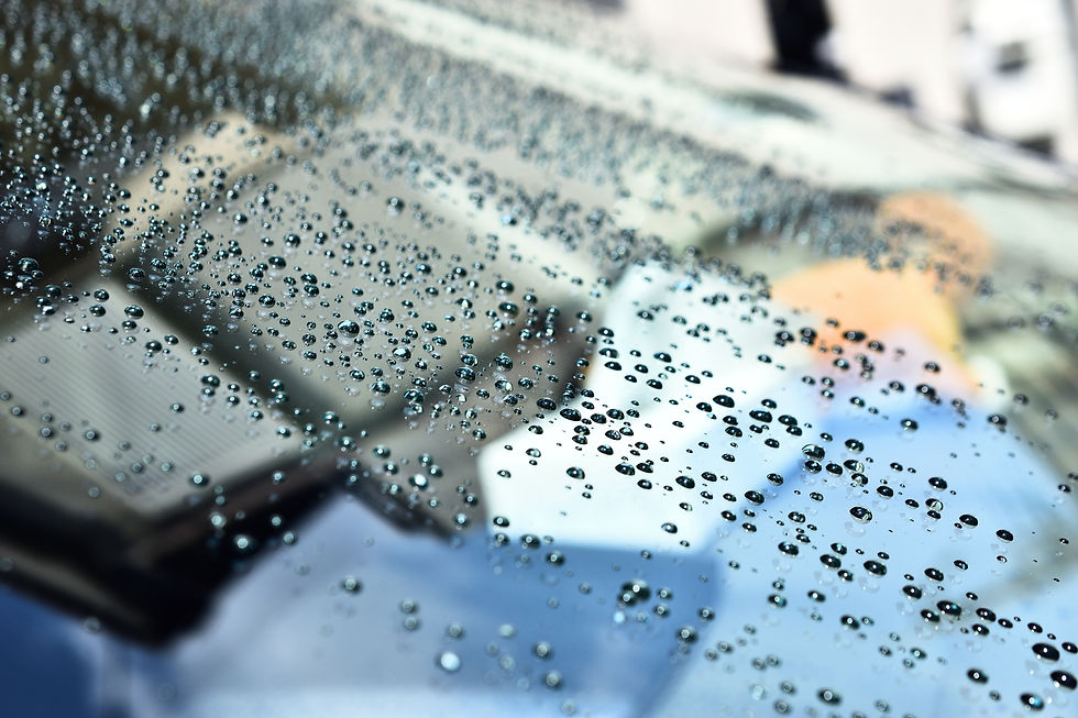 雨滴が付いた車のフロントガラスのクローズアップ、背景にぼやけた景色、詳細。