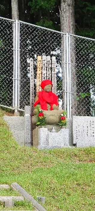 赤い帽子とよだれかけをつけた地蔵像