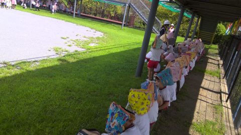 子供たちが整列している様子、帽子をかぶって、10月【年少】園外遠足、晴れた日の公園にて。