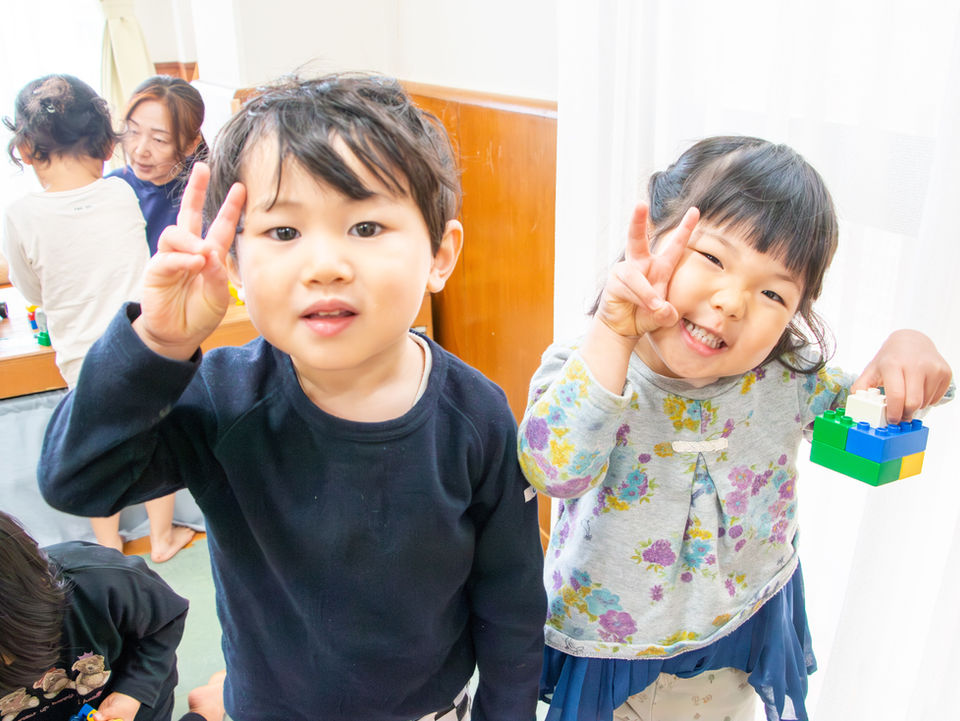 笑顔でピースサインをする2人の子ども
