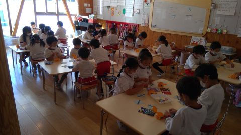 園児たちが工作に集中、教室風景。園児、マスク着用。机に向かい制作活動中です。7月【年長】盆踊り練習。