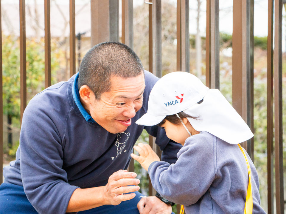 しゃがんで子供と話す大人