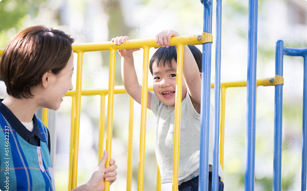 遊具で遊ぶ男の子と見守る保育士の入園案内イメージ