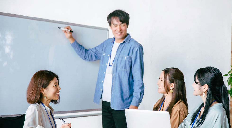 ホワイトボードで説明する男性と話を聞く女性たち