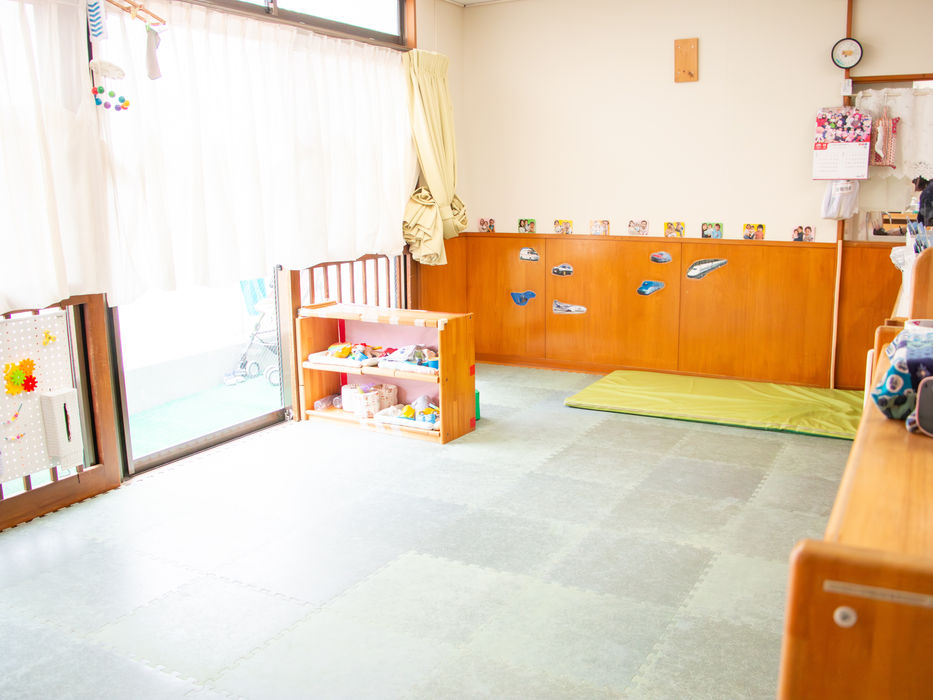 自然光が差し込む子供部屋、小さな棚と緑のマット